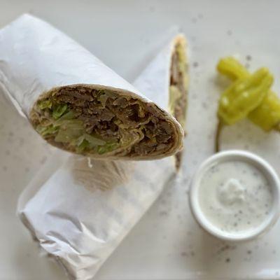 Wrap Marinated lamb and beef, slow-cooked and thinly sliced. with Salad, Hummus & Sauce Inside.