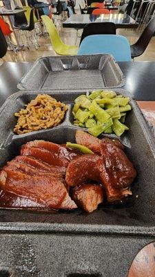 Two meat plate with green beans and dirty rice.