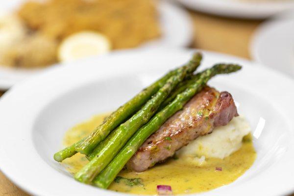 Honey Mustard Smoked Chop - A perfectly smoked bone in pork chop topped in honey mustard wine sauce with grilled asparagus and mashed potato
