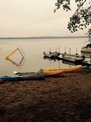 Kayaks and canoe with swimming area behind.
