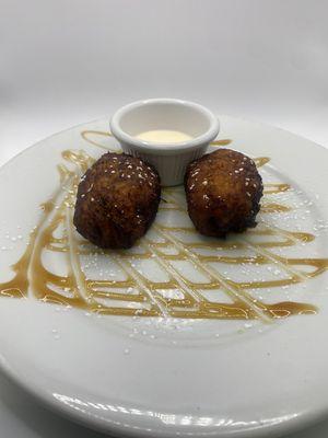 Guatemalan rellenitos, smashed plantain filled with refried beans Guatemalan cream on side
