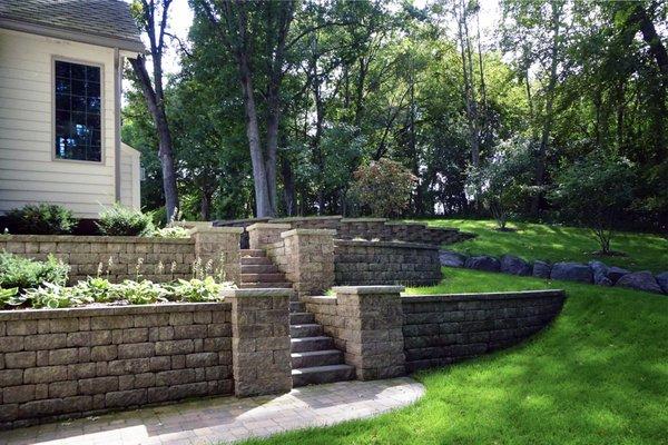 This retaining wall project included pavers, re-grading, planting, and boulders.