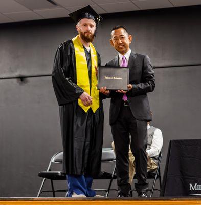Milwaukee Career College President, Jack Takahashi, posing with a graduate during the graduation ceremony.