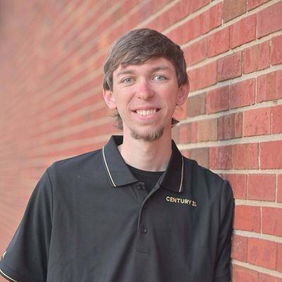 Gavin Devore in front of the Bloomington, IL Century 21 Quest office. Gavin serves for homes in Clinton, IL, and homes in Bloomington, IL.