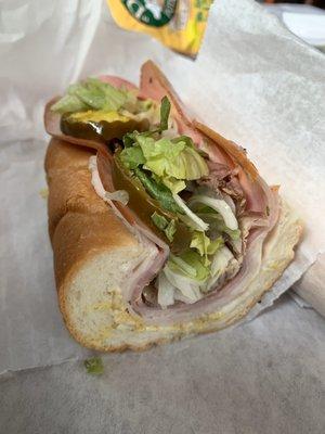 Half of a whole white sub sandwich full of meat and veggies! A half is HUGE!