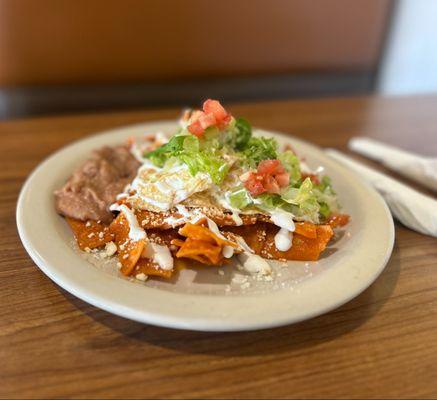 Breakfast chilaquiles served with eggs and beans.
