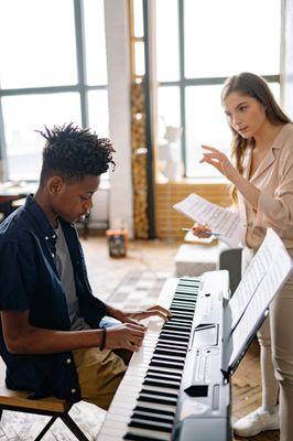Teacher instructing piano student