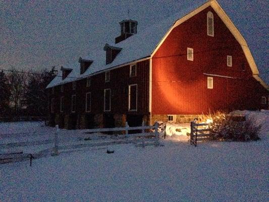 Beautiful barn glistening on a snowy evening.