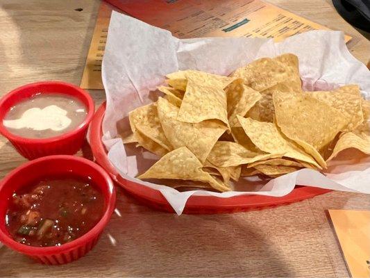 Complementary chips and salsa. Salsa good 3/10 spiciness and cheese in beans.