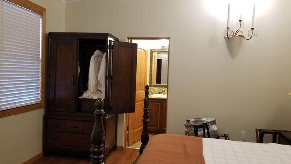 Armoire with robes.