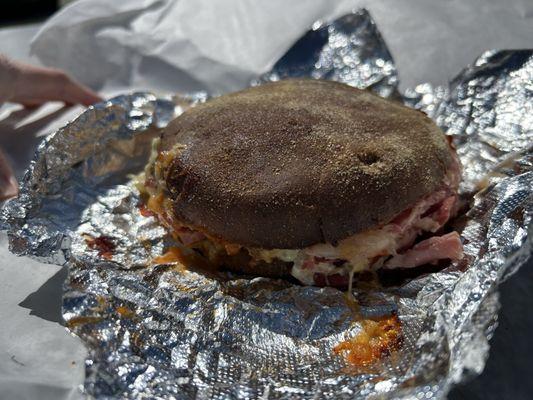 Oven Baked Rueben on fresh baked rye bun featuring thin sliced corned beef brisket, swiss cheese, sauerkraut & 1000 island dressing