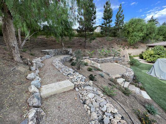 Gabion wall with stone pathways accessing slope in Thousand Oaks backyard.
