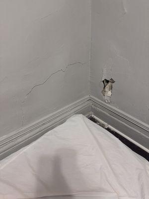 This is the room with a hole in the wall and a dirty mattress on the floor