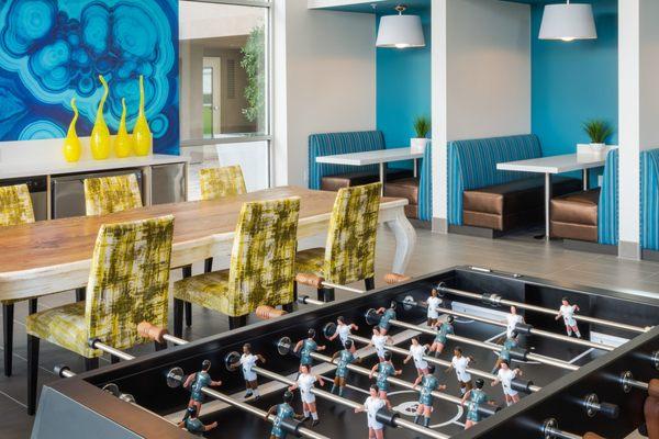 Clubhouse with dining seating, foosball table, and kitchen.