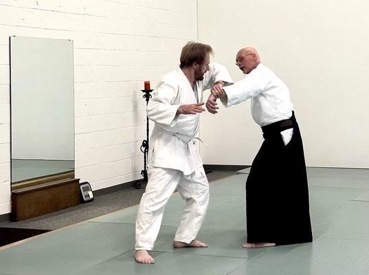 Guy is a black belt showing a white belt a hold