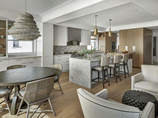 A sunlit kitchen and breakfast room by Jaffe Architecture--marble island, brass accents, and custom cabinetry define quiet luxury.