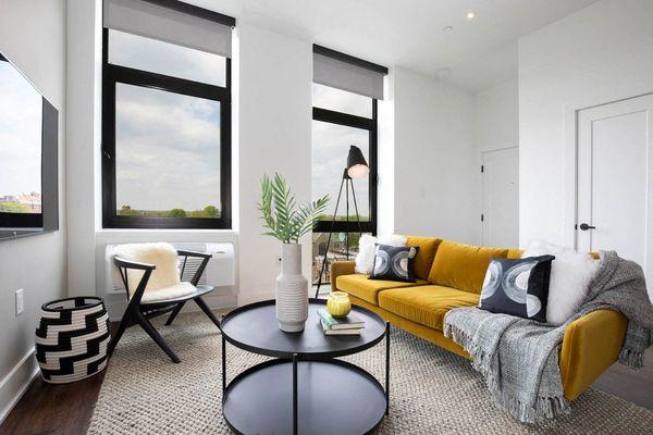 a living room with a yellow couch and a table