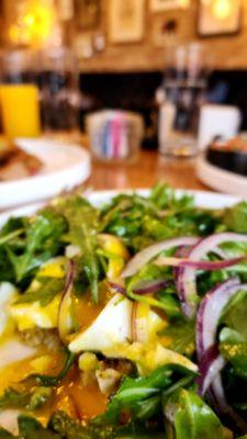 Arugula salad over avocado toast with poached eggs.