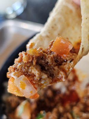 A Chip with a part of the Choriqueso dip.