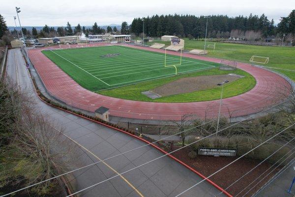 Aerial shot of turf field and campus entrance