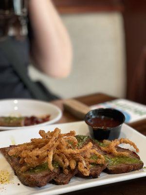 Steak bites appetizer with chimichurri sauce. That to me it looked and tasted more like strips of tri-tip. We were disappointed.
