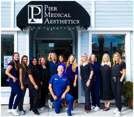 Group photo of the Pier Medical Aesthetics team standing outside the clinic's entrance at 415 Pier Avenue, Hermosa Beach, CA.