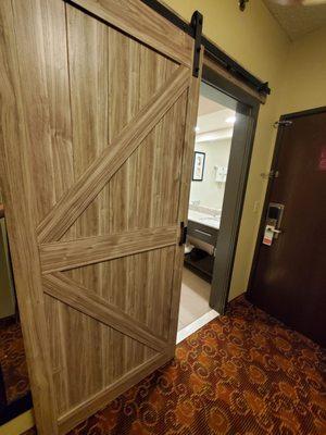 Barn door into bathroom. Bad idea since when open, you can see right into the shower that is sheer/see through halfway up.