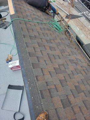 Installing new shingles over the roof.