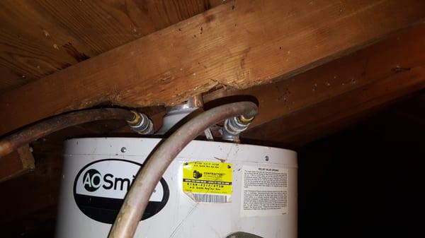 Water heater Is improperly installed by altering the roof decking. The flue & draft diverter are not secured creating an unsafe condition.