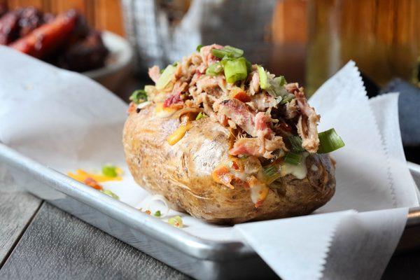 Idaho Stuffed Pig. A BIG OL' smoked potato stuffed with Carolina Pulled Pork, cheddar cheese, green onion, butter and sour cream.