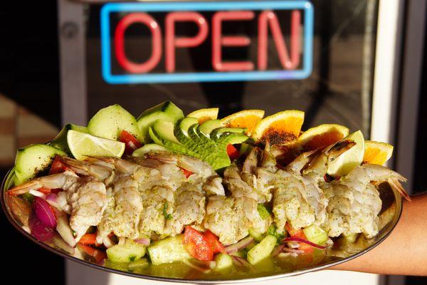 Aguachiles, are shrimped cooked in lime choice and served with a lime based green sauce along with tomatoes, onion, cilantro, cucumbers, etc