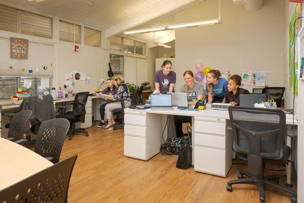 DFX therapists sitting and standing in their co-working area in the clinic