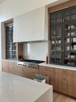 A luxurious kitchen with a large white quartz island and a backsplash made of the same material...