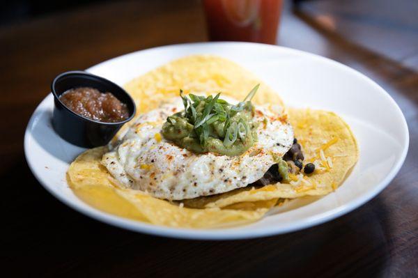 Huevos Rancheros - Three corn tortillas topped with black beans, cheddar, salsa, guacamole and three eggs cooked to order - $12