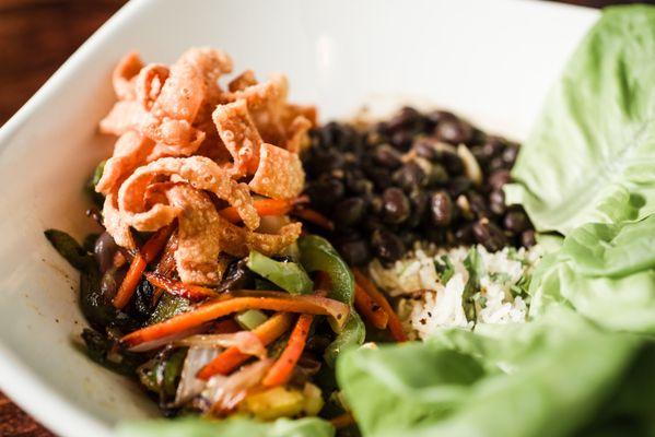 Lettuce Wrap Bowl - Sesame ginger stir-fried peppers, onions, carrots, mushrooms, water chestnuts, wonton strips, black beans, rice.