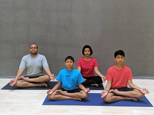 The Maniar family meditates together.