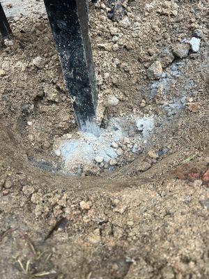 They dumped a small cup of cement powder on top - no water added and then took stones from neighbors yard and jammed into the ground
