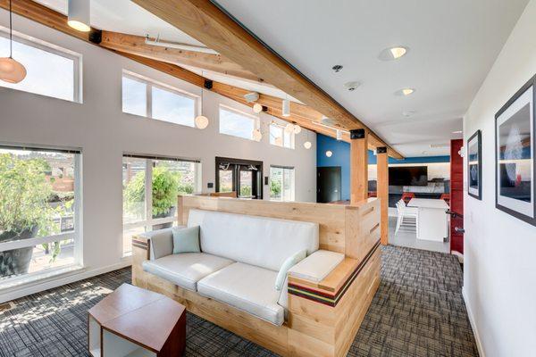 Clubhouse with bar seating, exposed beams, tables and chairs.