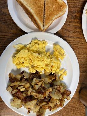 Scrambled eggs and fried potatoes with toast.