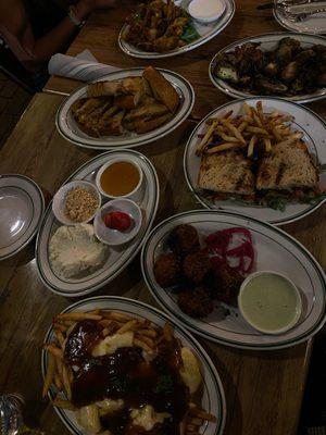 Top to bottom: Artichoke, brussels sprouts, eggplant sandwich, whipped feta with bread, chili croquettes, and poutine.