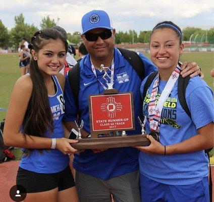 Coach Fernandez with his daughters after securing a team second place finish at state track in spring 2017.