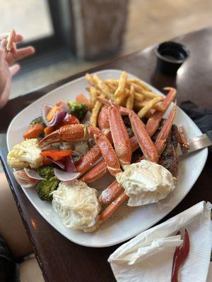 New York strip steak with crab legs, side of vegetables, and french fries