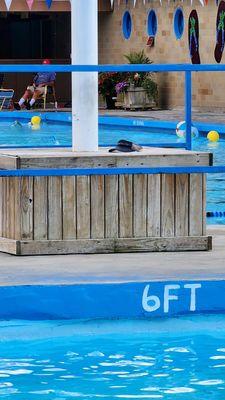 Cement light post near deep end of pool