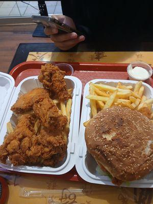 Chicken sandwich with fries, and drumsticks and wings with fries also.