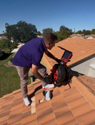 Inspector performing sewer scope on roof