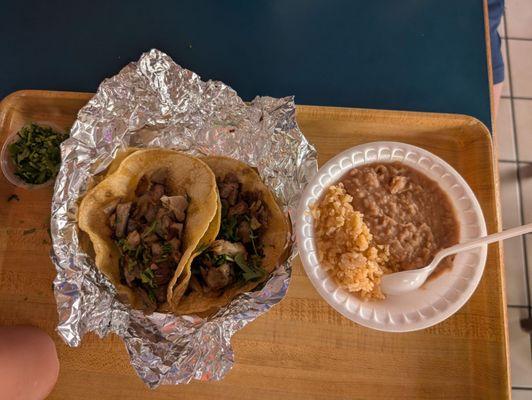 Two carnitas soft tacos, beans and rice. The red sauce on the side was delicious. Mild with only a slight kick.