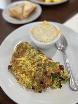 High omelet - bacon, broccoli, eggs and cheese. I added sour cream. Grits
