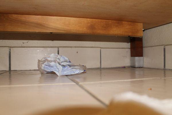 Trash left under the vanity.