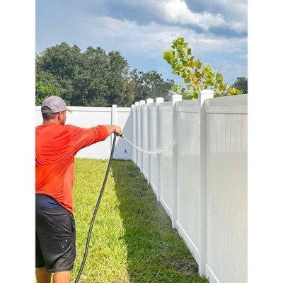 A beautiful sunny day and Sergio cleaning a newly installed White Privacy Vinyl Fence.