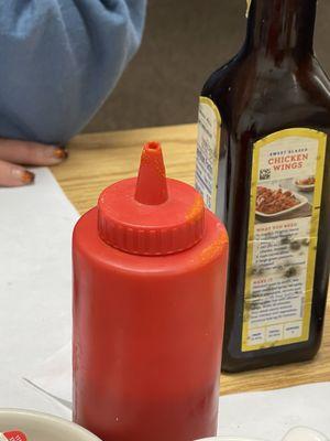 Old dry sauce down the lid. Mold spores on the steak sauce bottle behind it.